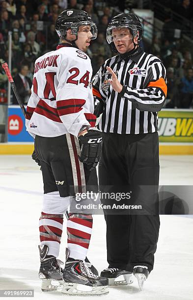 Referee Sean Reid discusses a call with Scott Kosmachuk during a stoppage against the Edmonton Oil Kings in Game Two of the 2014 Mastercard Memorial...