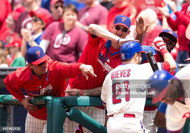 Cather Will Nieves of the Philadelphia Phillies is greeted by cather Carlos Ruiz, pitcher A.J. Burnett, and outfielder Tony Gwynn Jr. #19 after Will...