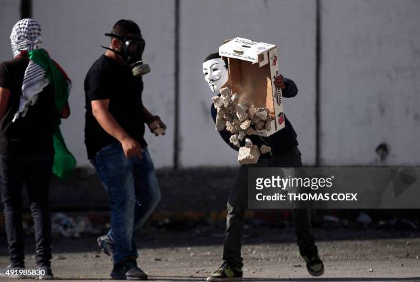 Palestinian demonstraters gather a pile of stones to throw towards Israeli security forces during clashes in the Palestinian neighbourhood of Shuafat...