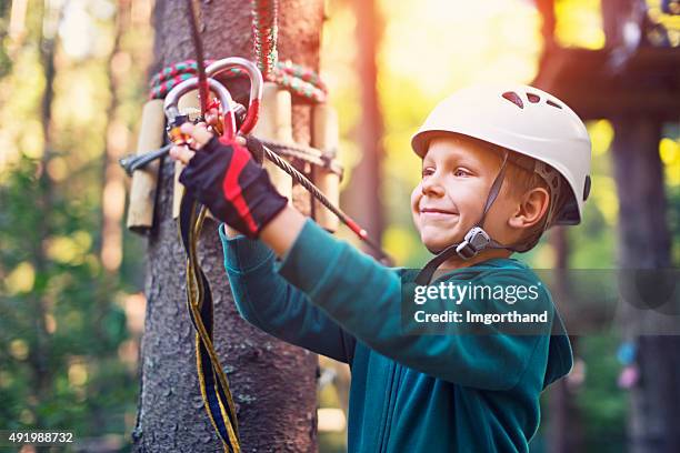 zuversichtlich jungen befestigung mit karabiner, zip line. - hochseilgarten stock-fotos und bilder