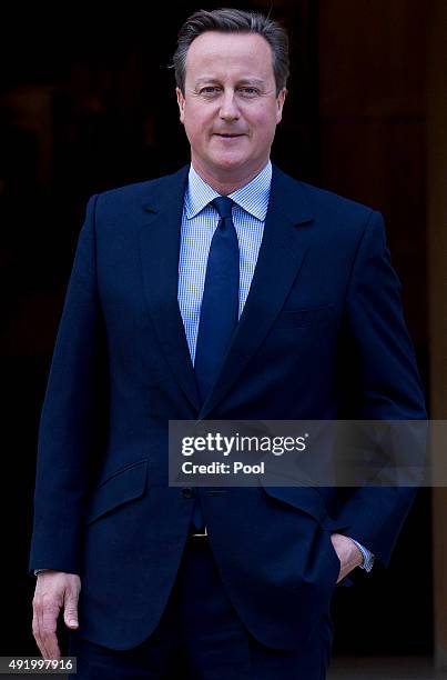 British Prime Minister David Cameron waits to greet German Chancellor Angela Merkel ahead of their meeting at Chequers, the Prime Minister's country...