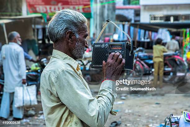 old man listening to an old fashioned radio set - listening to radio stock pictures, royalty-free photos & images