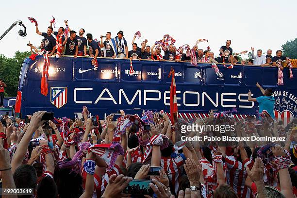 Club Atletico de Madrid players arrive on bus celebrating with the fans after their tenth La Liga title at Neptuno Square on May 18, 2014 in Madrid,...
