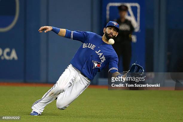 Jose Bautista of the Toronto Blue Jays dives to make a catch and end the seventh inning against the Texas Rangers during game two of the American...