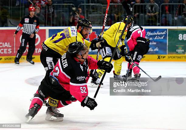 Alexander Sulzer of Koelner is checked by Scott Valentine Krefeld Pinguine battle for the puck during the DEL Ice Hockey match between Koelner Haie...