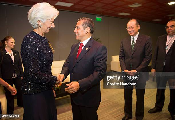 In this handout image provided by the International Monetary Fund, International Monetary Fund Managing Director Christine Lagarde is greeted by Peru...