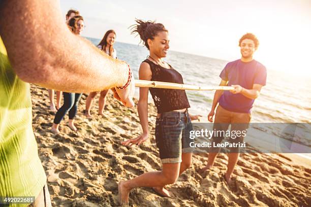 limbo-spiel am strand - limbo stock-fotos und bilder