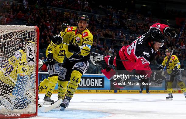 Ryan Jones of Koelner Haie and Nicolas St.Pierre of Krefeld Pinguine battle for the puck during the DEL Ice Hockey match between Koelner Haie and...