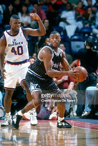 Nick Anderson of the Orlando Magic looks to pass the ball while guarded by Calbert Cheaney of the Washington Bullets during an NBA basketball game...