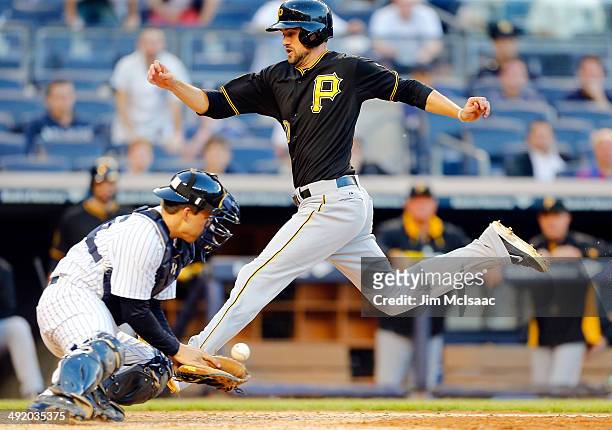 Jordy Mercer of the Pittsburgh Pirates scores a run in the ninth inning on a sacrifice fly as John Ryan Murphy of the New York Yankees can't come up...