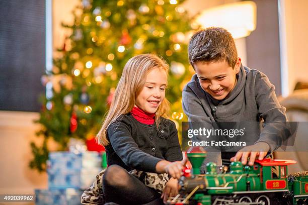 brother and sister watching a toy train - boys wearing tights 個照片及圖片檔