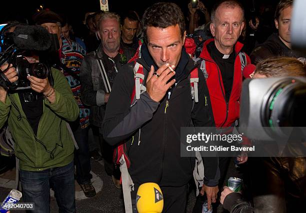 Former Societe General trader Jerome Kerviel, assisted by priest Patrice Gourrier , surrenders to police at the French border on May 18, 2014 in...