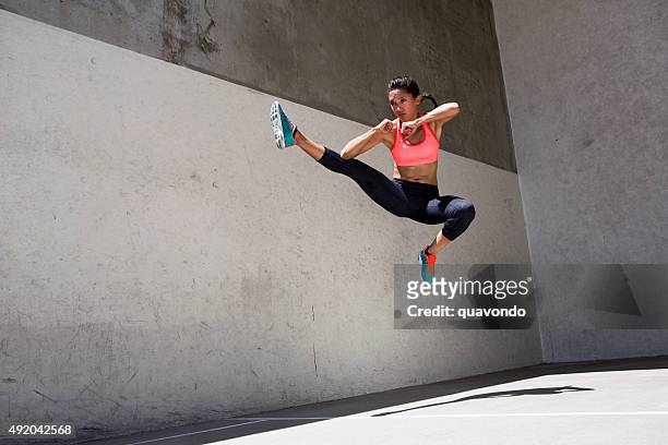 attractive brunette female athlete jumping in the air - aanvallen sporten stockfoto's en -beelden