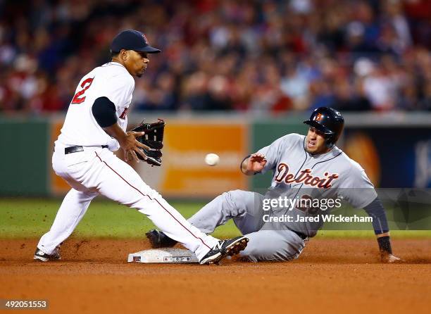 Martinez of the Detroit Tigers slides safely into second base in front of Xander Bogaerts of the Boston Red Sox for a stolen base during the game at...