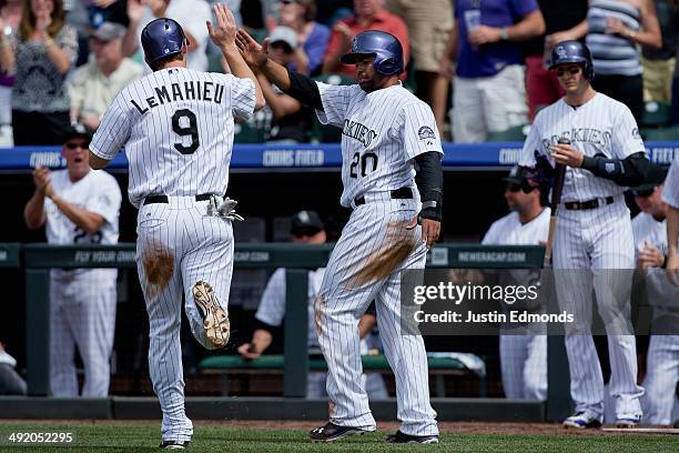 LeMahieu of the Colorado Rockies celebrates with Wilin Rosario after scoring during the third inning against the San Diego Padres at Coors Field on...