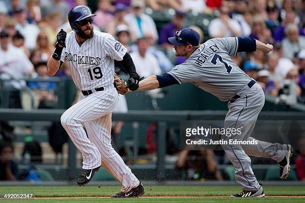 Chase Headley of the San Diego Padres tags out Charlie Blackmon of the Colorado Rockies during a run down for the second out of the seventh inning at...
