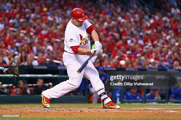Matt Holliday of the St. Louis Cardinals hits an RBI single in the first inning against the Chicago Cubs during game one of the National League...