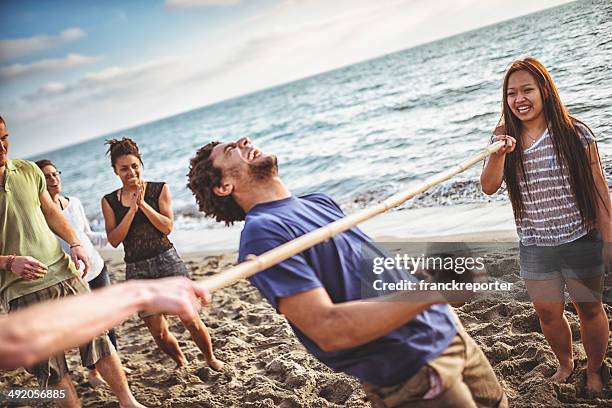 amigos jugando al limbo en la playa - limbo fotografías e imágenes de stock