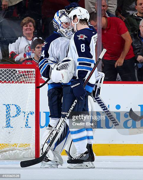 Michael Hutchinson of the Winnipeg Jets is congratulated by teammate Jacob Trouba after the 3-1 win over the New Jersey Devils on October 9, 2015 at...