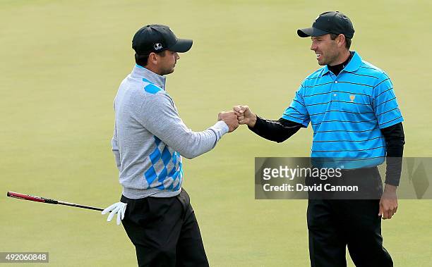 Charl Schwartzel of South Africa and the International Team congratulates his partner Jason Day of Australia after Day had holed a tricky birdie putt...