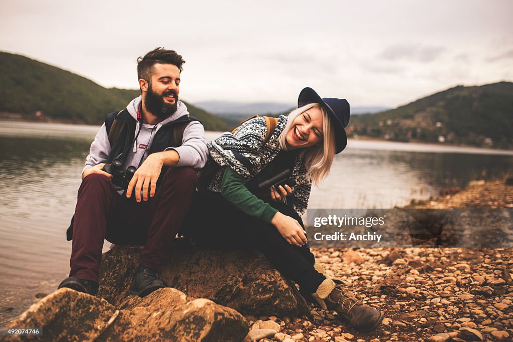 Young smiling couple enjoying nature and their hiking together