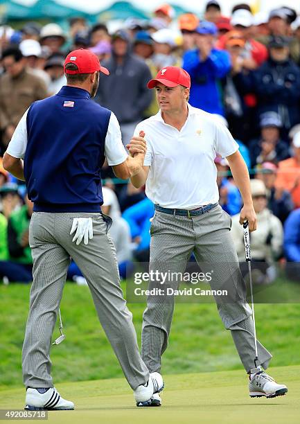 Jordan Spieth of the United States team is congratulated by his partner Dustin Johnson after he had holed a match winning par putt on the 18th hole...
