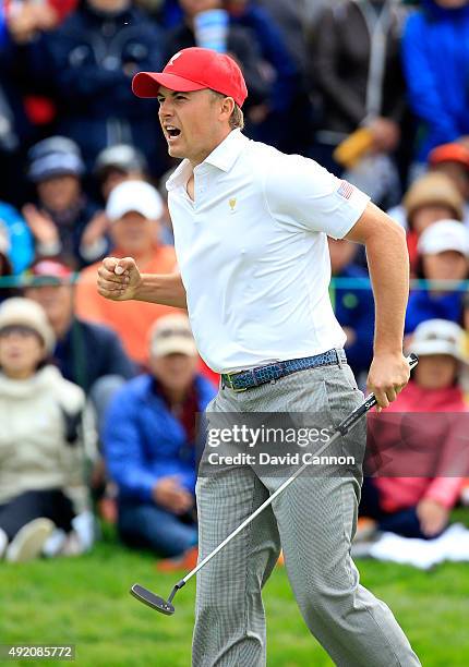 Jordan Spieth of the United States team celebrates as he holed his match winning par putt on the 18th hole in his match with Dustin Johnson against...