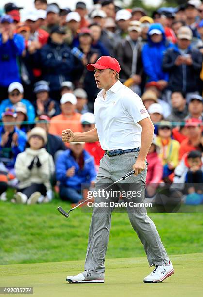 Jordan Spieth of the United States team celebrates as he holed his match winning par putt on the 18th hole in his match with Dustin Johnson against...