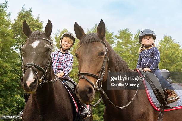 kids on horses brother and sister horseback riding - child horse stock pictures, royalty-free photos & images