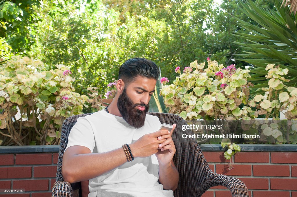 Asian Pakistán hombre usando un teléfono móvil