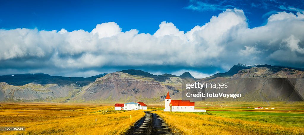 Red roof church and rural village farmhouses cloudscape panorama Iceland