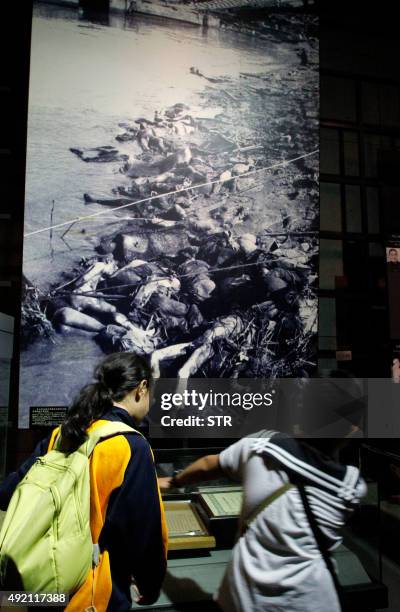 Visitors look at photos on display at the Nanjing Massacre Memorial Hall in Nanjing on October 10, 2015. Japan on October 10 lashed out at UNESCO's...