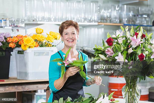 florist arranging bouquet of flowers in vase - kali rose stock pictures, royalty-free photos & images