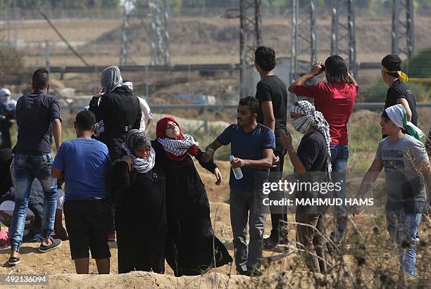 Palestinian protester is evacuated by comrades after inhaling tear gas during clashes with Israeli security forces near the Nahal Oz border crossing...