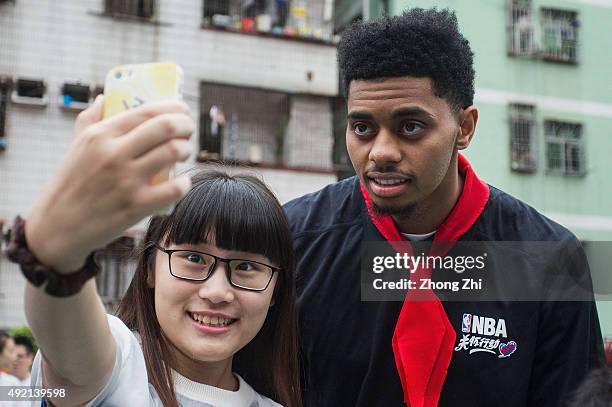 Jeremy Lamb of Charlotte Hornets interacts with a fan during the Shenzhen Learn and Cares dedication as part of the 2015 Global Games China at the...