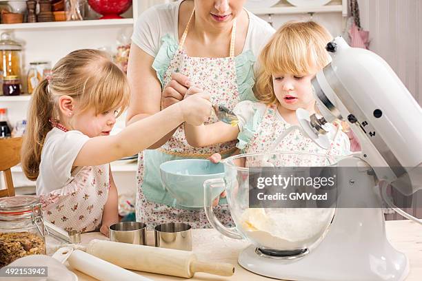 two little girls preparing cookies in the kitchen - electric whisk stock pictures, royalty-free photos & images