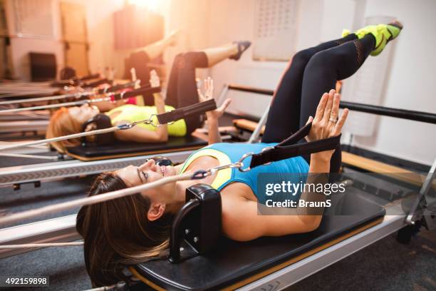 pilates exercises on machines in a health club. - reformer stock pictures, royalty-free photos & images