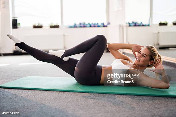 giovane atleta femmina esercitando sit-up in un health club. - sit up foto e immagini stock