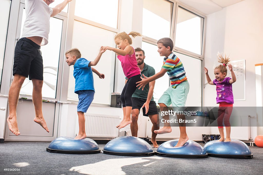 Small children jumping on bosu balls on training class.