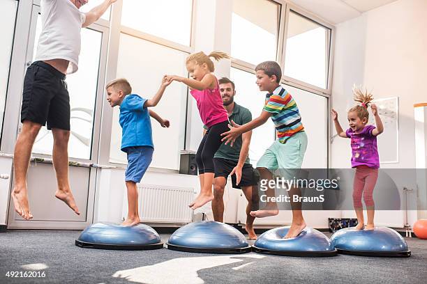 small children jumping on bosu balls on training class. - kids gymnastics stock pictures, royalty-free photos & images