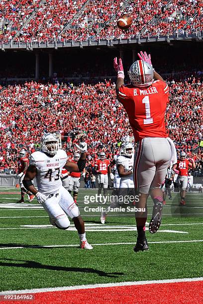 Braxton Miller of the Ohio State Buckeyes catches a 19-yard touchdown pass in the second quarter as Jalen Brooks of the Maryland Terrapins closes in...