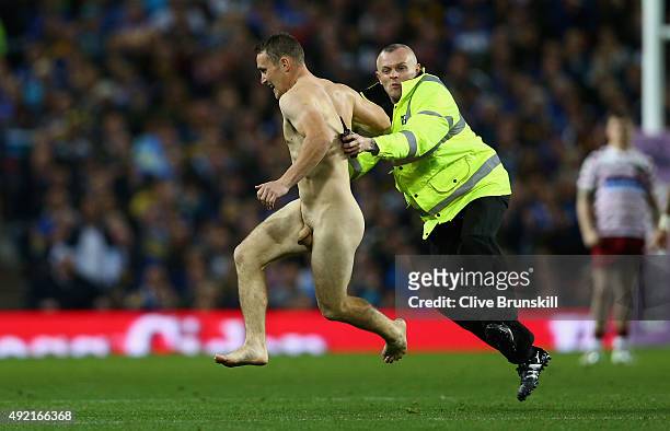 Streaker is tackled by a steward during the First Utility Super League Grand Final between Wigan Warriors and Leeds Rhinos at Old Trafford on October...