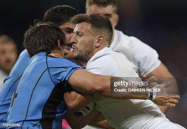 England's scrum half Danny Care is tackled during the Pool A match of the 2015 Rugby World Cup between England and Uruguay at Manchester City Stadium...