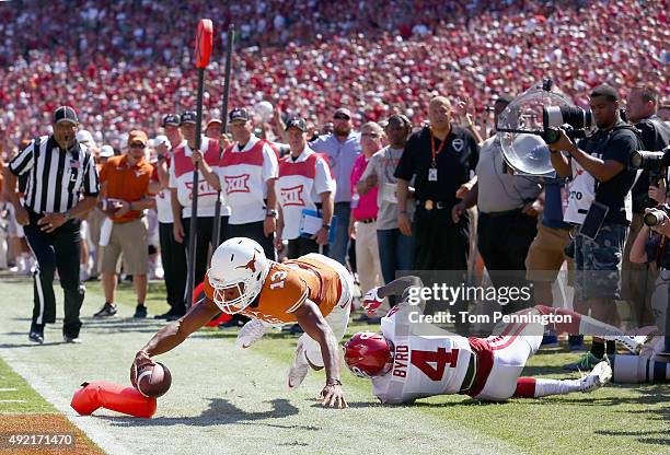 Jerrod Heard of the Texas Longhorns dives into the end zone with the ball against Hatari Byrd of the Oklahoma Sooners in the second half during the...