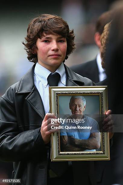 Jamie Hafey-Bagg grandson of Tom Hafey holds a picture of him during the public service for Tom Hafey at Melbourne Cricket Ground on May 19, 2014 in...