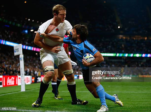 Joe Launchbury of England is pulled by Alejo Duran of Uruguay during the 2015 Rugby World Cup Pool A match between England and Uruguay at Manchester...