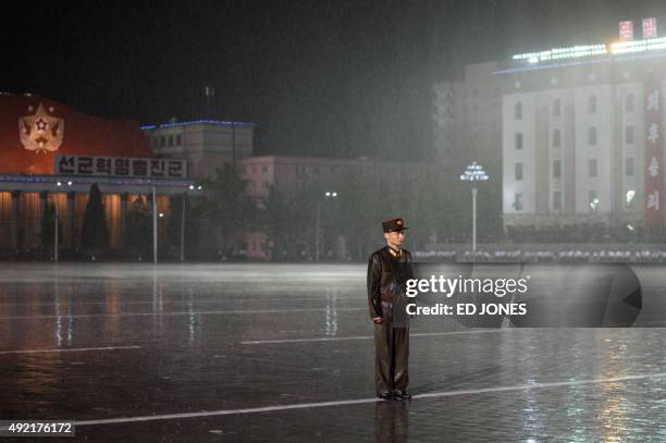North Korean soldier stands in the rain on Kim Il-Sung square following a mass military parade in Pyongyang on October 10, 2015. North Korea was...