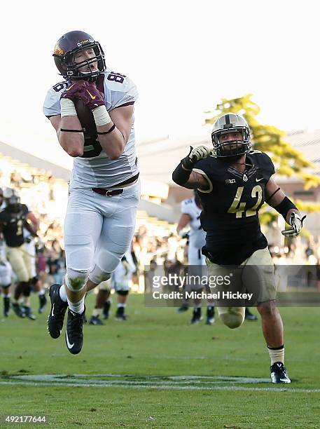 Brandon Lingen of the Minnesota Golden Gophers make a catch in the end zone for a touchdown as Andy James Garcia of the Purdue Boilermakers trails at...