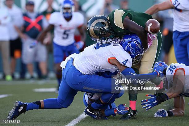 Running back Dalyn Dawkins of the Colorado State Rams fumbles the ball as he is tackled by Darian Thompson of the Boise State Broncos and was...