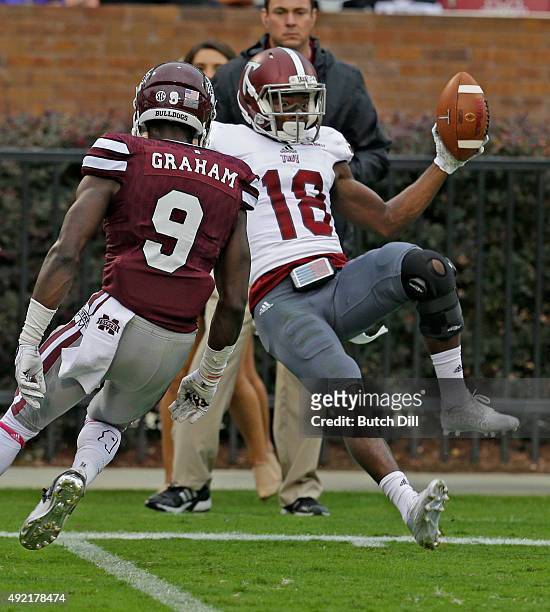 Wide receiver Bryan Holmes of the Troy Trojans pulls in a reception over defensive back Jamoral Graham of the Mississippi State Bulldogs during the...